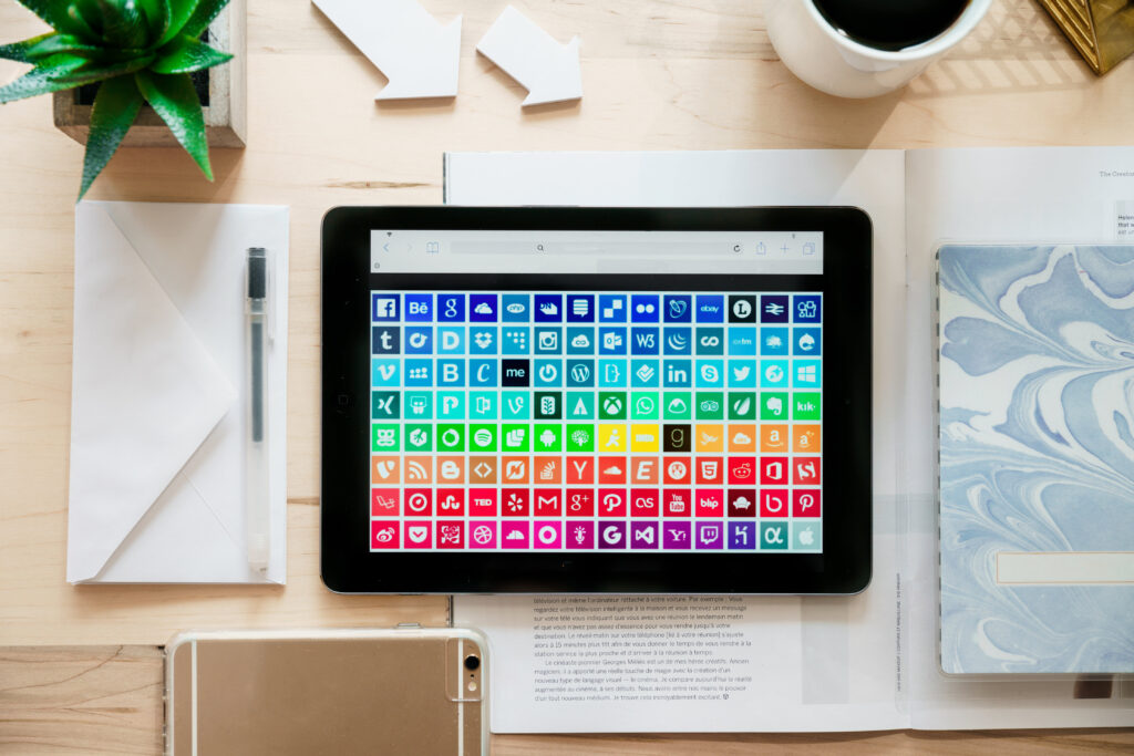 social media logos displayed on tablet in rainbow gradient